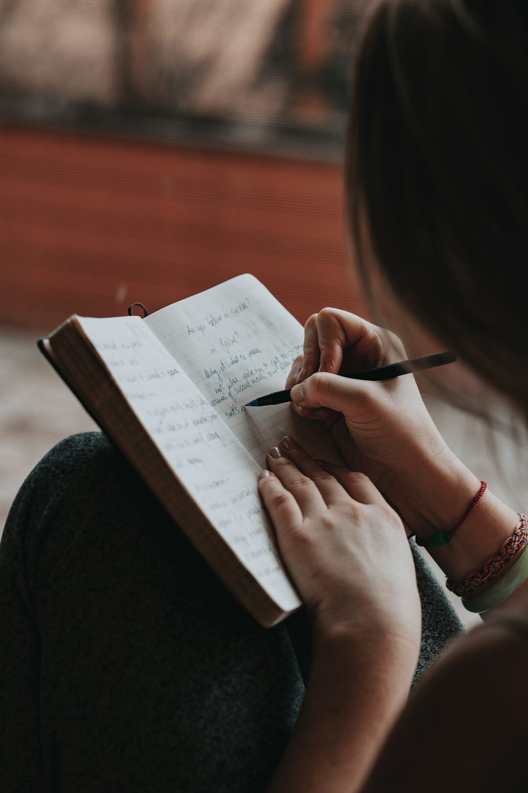 person writing in notebook